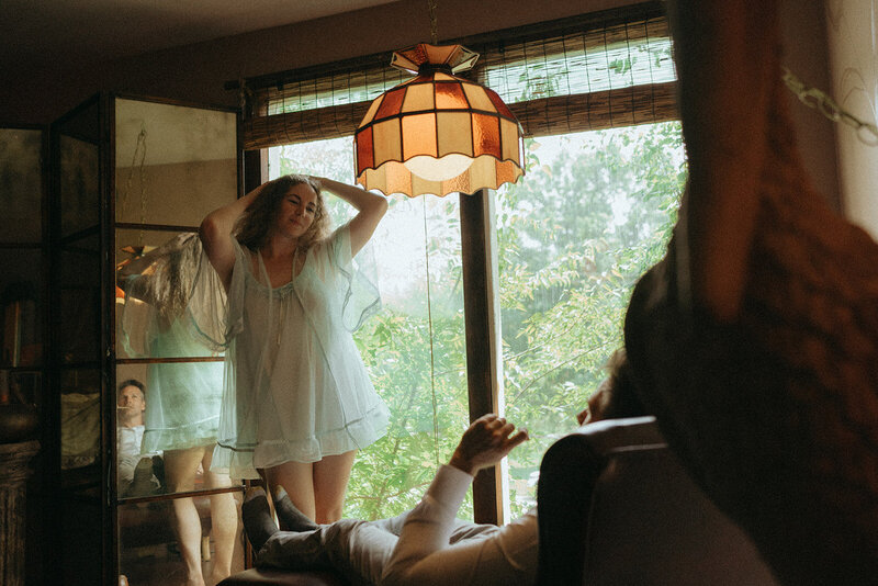 woman posing in front of man during couples photos, captured by Elsie Goodman, an NYC couples photographer