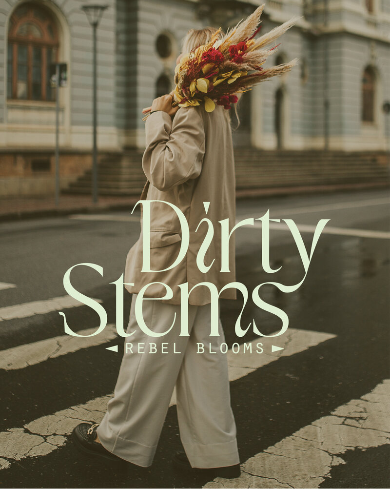 woman walking in a city crosswalk holding flowers and a logo for Dirty Stems Rebel Blooms flower shop