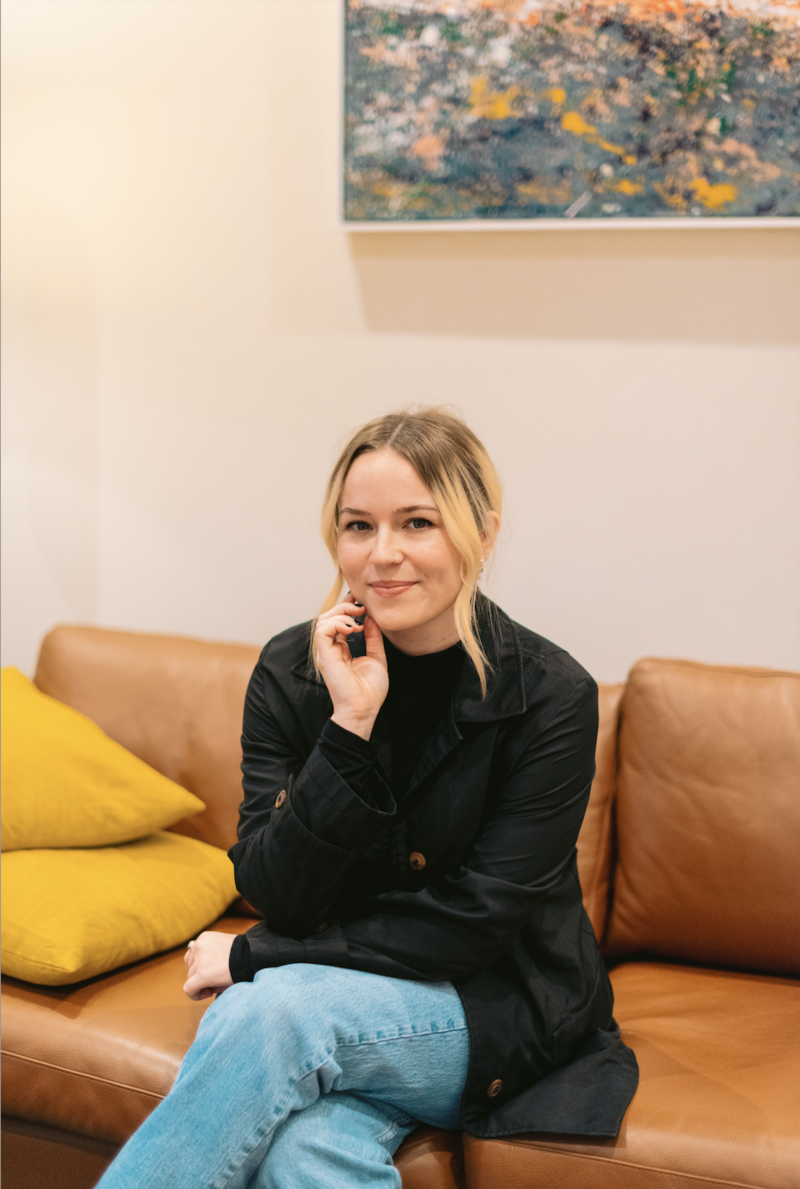 Kids therapist in Raleigh sitting on couch looking at camera