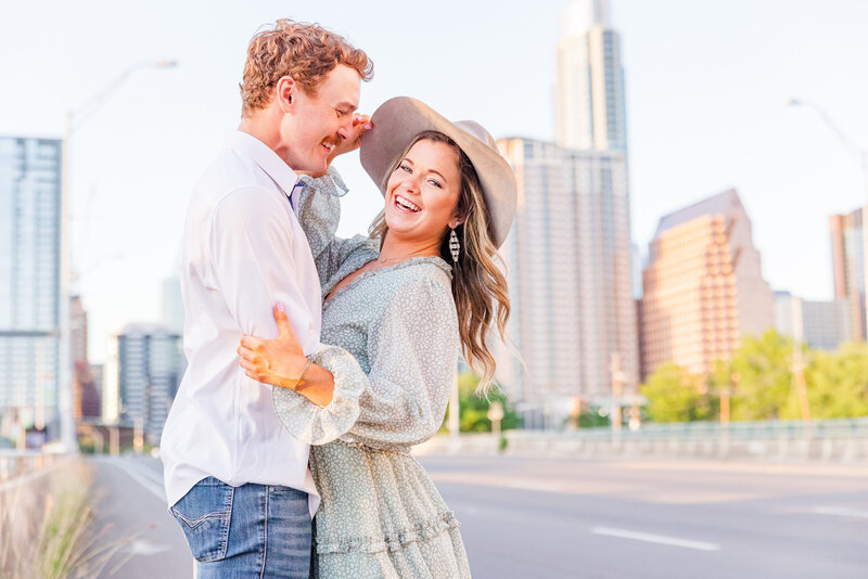 Couple sway along the congress parkway bridge during their engagement session in Austin, Texas. Photo taken by Austin Engagement Photographers, Joanna & Brett Photography
