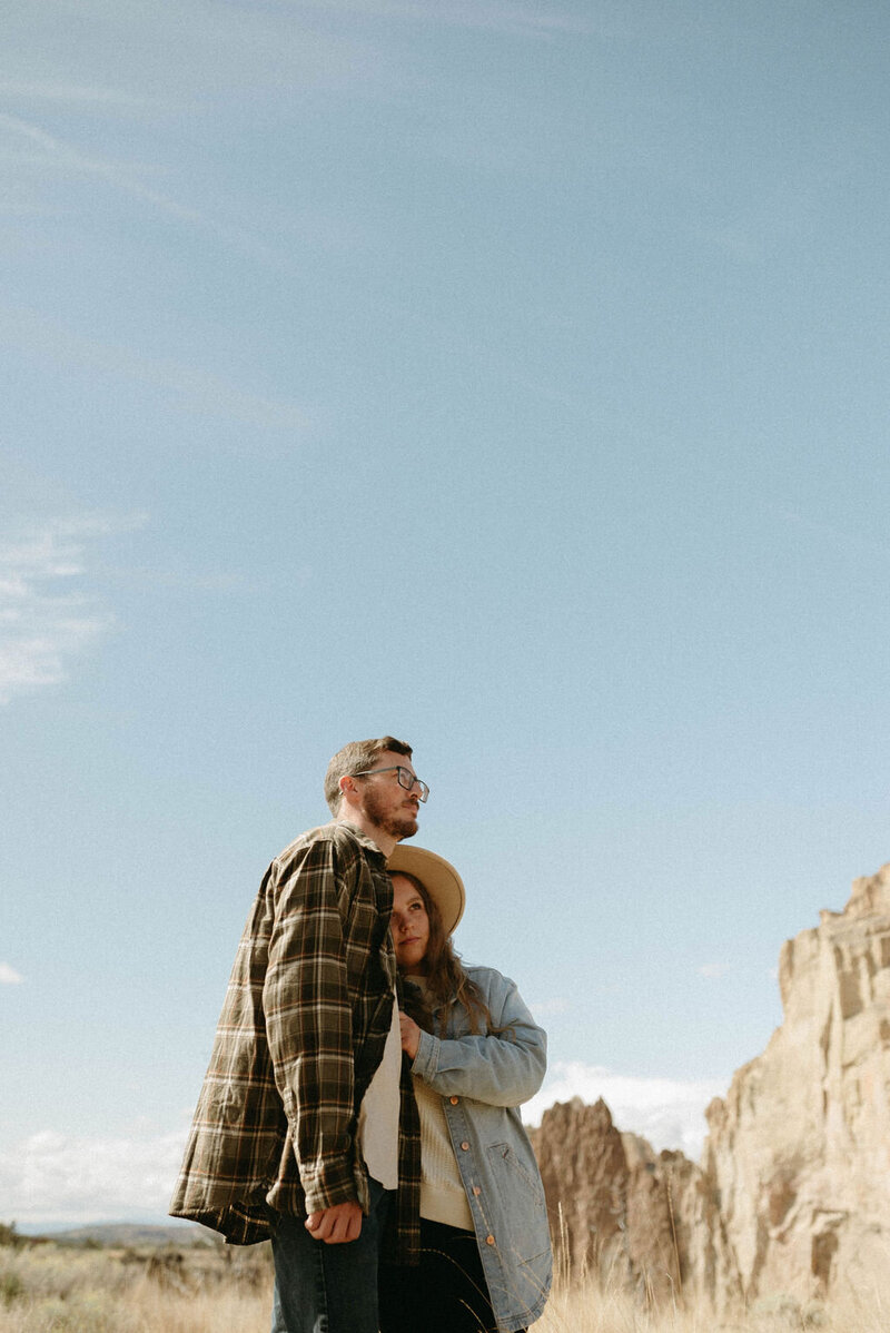 Couple sharing an intimate moment at Smith Rock State Park in Oregon, with dramatic rock formations and sweeping views.