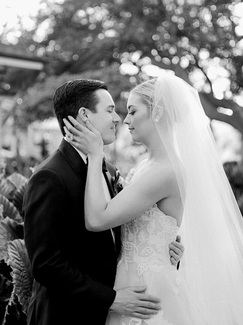 Bride and groom laugh nose to nose outside