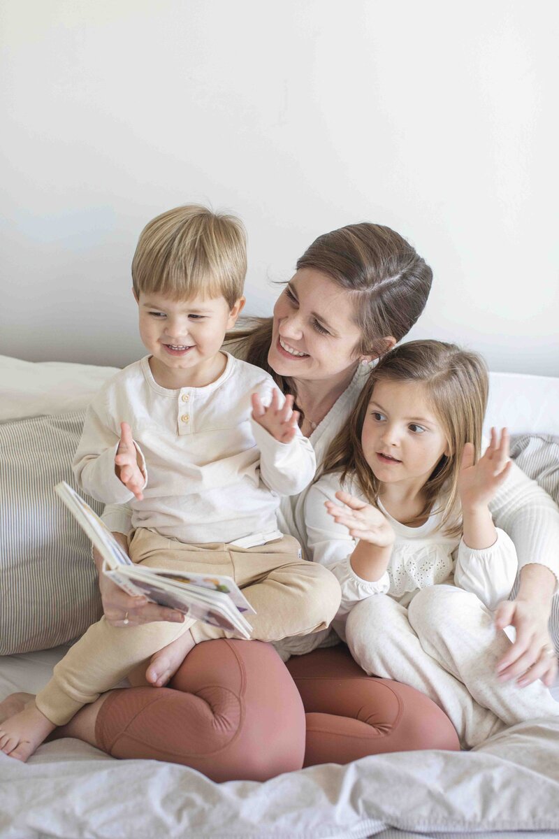 woman reading book to children