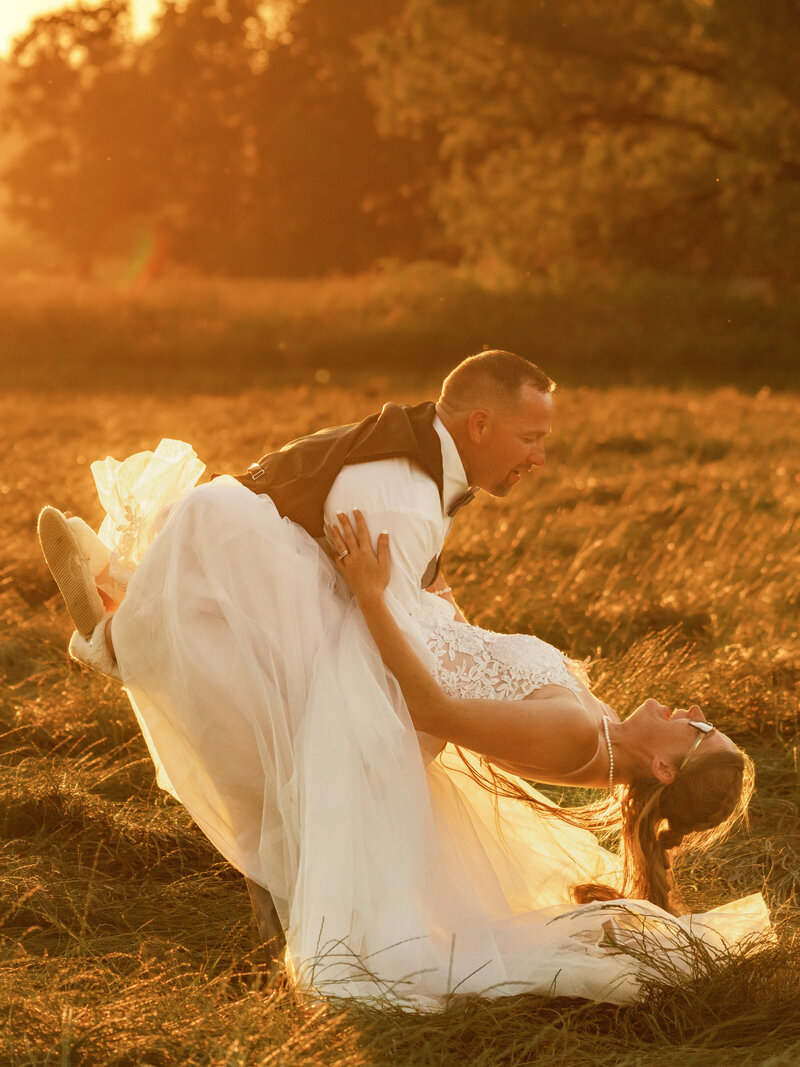 Captivating photograph capturing a groom dipping his bride during a breathtaking sunset, set against the idyllic backdrop of Half Moon Bay.