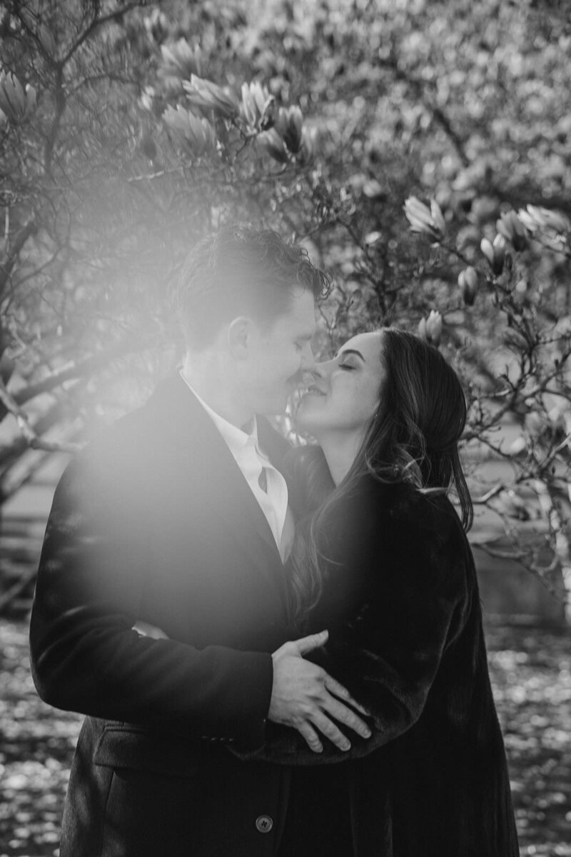 A wedding couple with their arms around each other about to kiss