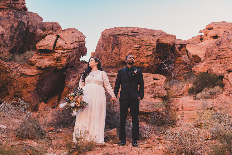 bride and groom hold hands in the Valley of Fire after their las vegas elopement ceremony