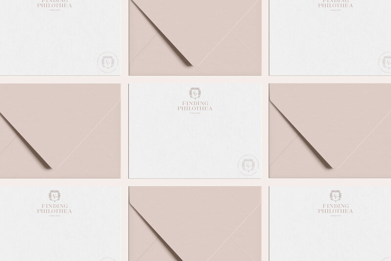 a mockup showing a gold logo on white stationery with blue envelopes