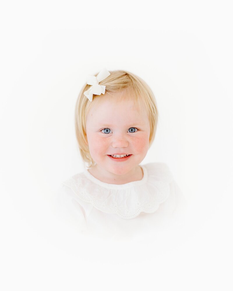 Young girl in blue dress seated for heirloom portrait – fine art children’s photography in OKC