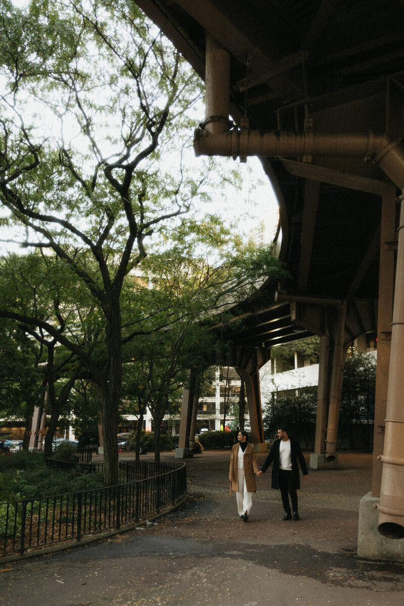 Couple holding hands and walking through a park in the Seaside District of New York City, NY, documented by Andrea-Marie Photography