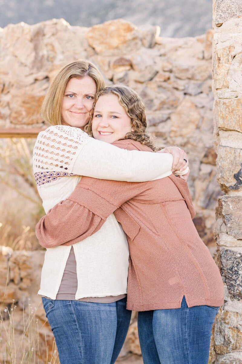 Mom and teenage daughter sharing a hug and smiling