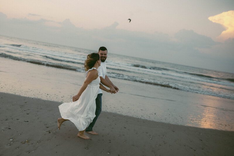 engagement photos couple running down beach
