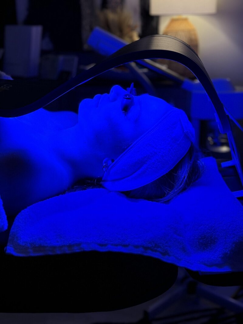Woman laying under Celluma LED Light therapy machine