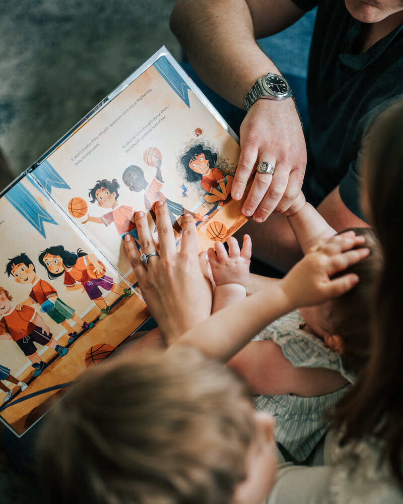 family of four smiling in woods together