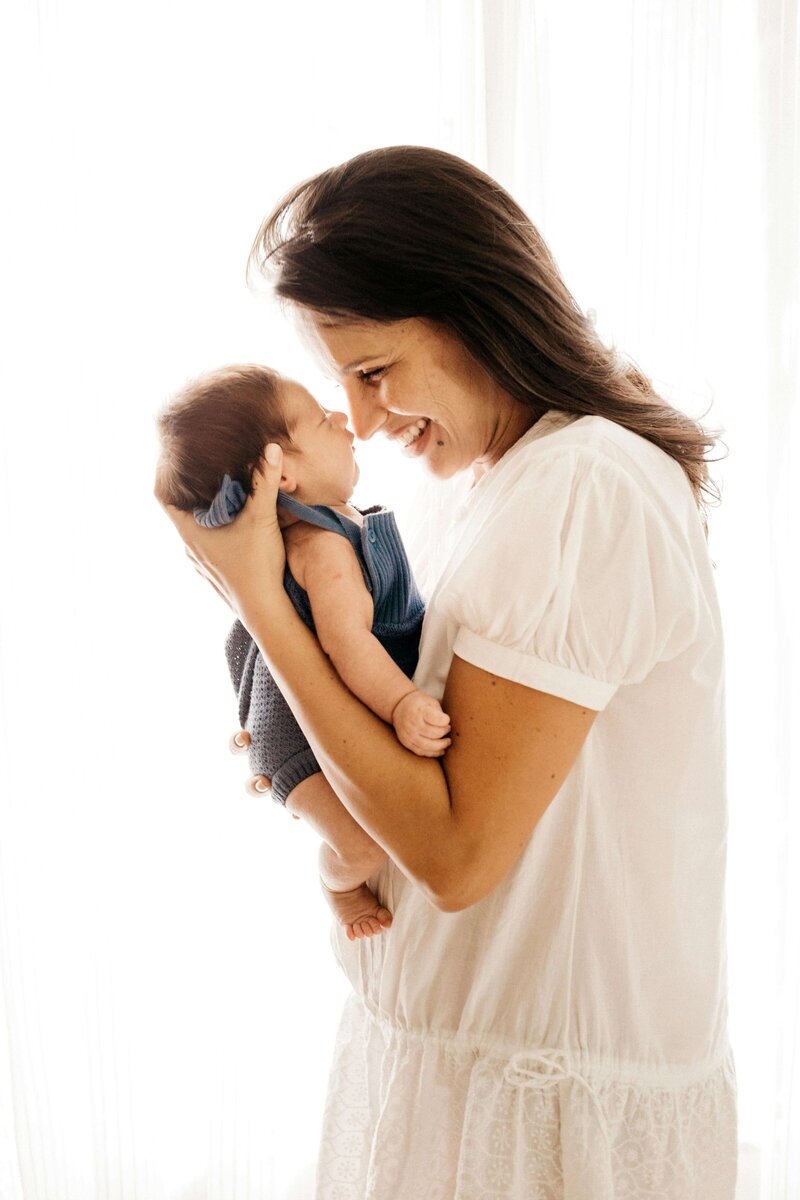 Woman touching noses with newborn baby