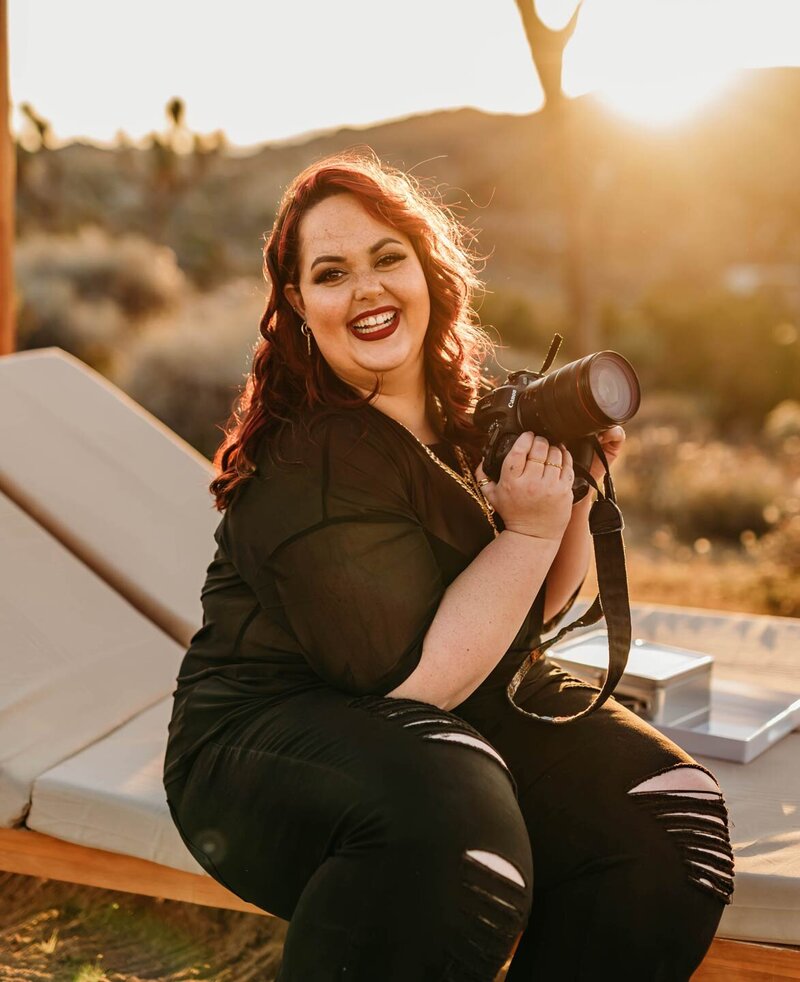 Larissa, destination wedding photographer, holding camera in California.
