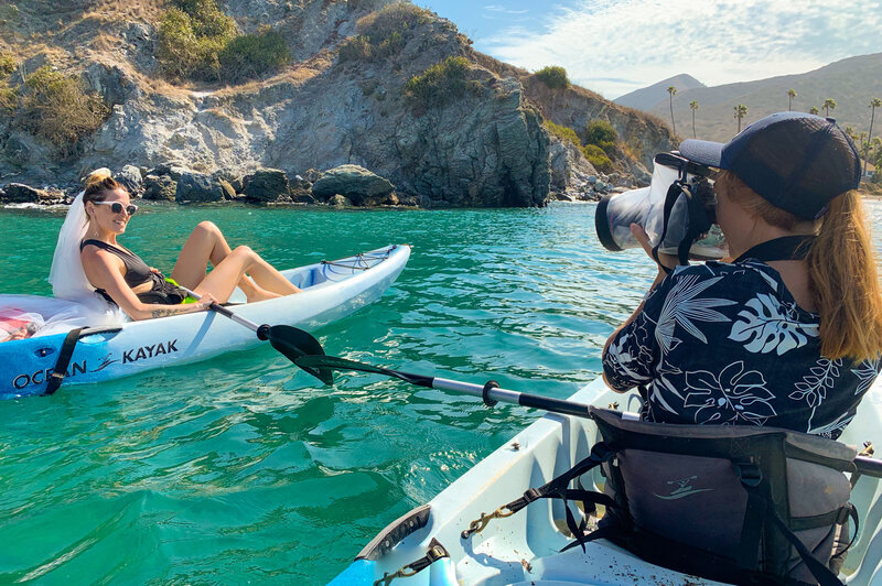 woman photographs couple on kayaks