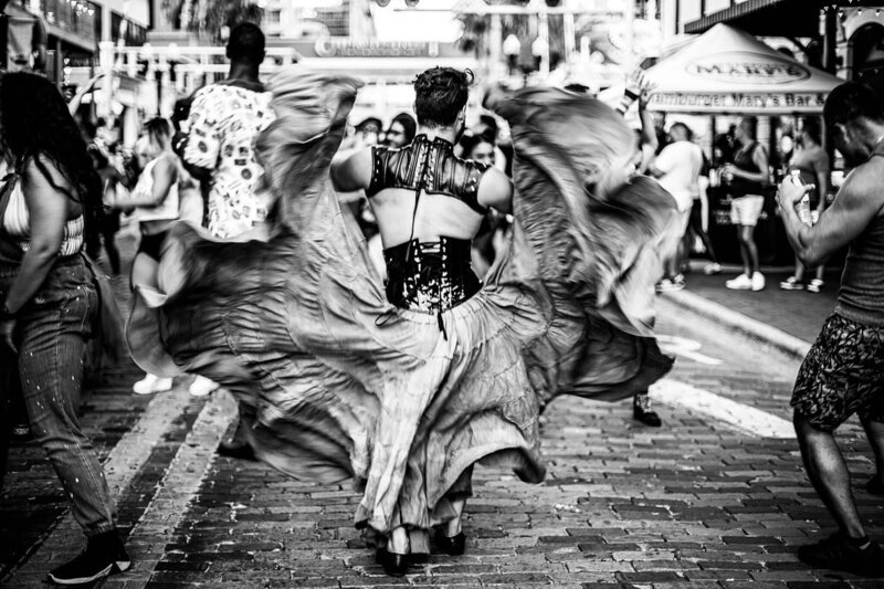 Black and white photo of dancer with big skirt dancing in the streets