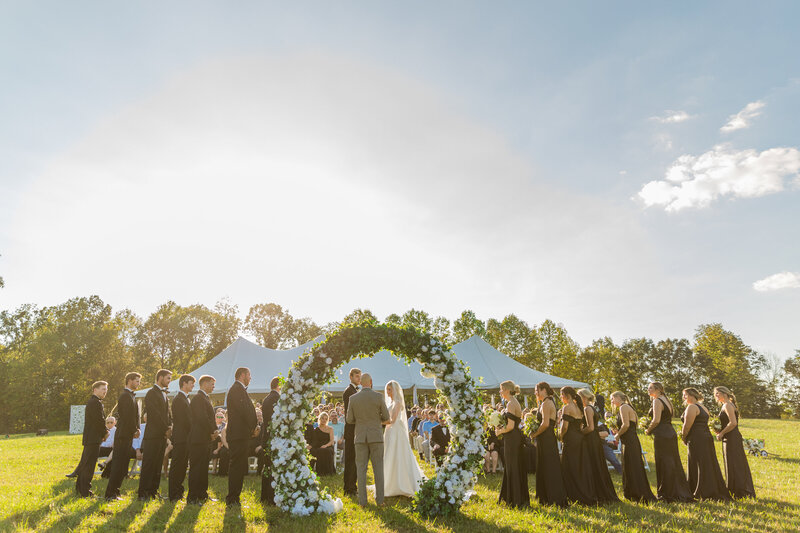 Bride and groom exchanging a heartfelt look during their vows at a scenic wedding ceremony location.