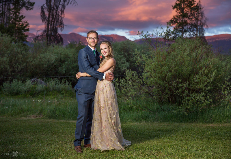 Couple poses with pretty purple mountains and sunset at B Lazy 2 Ranch