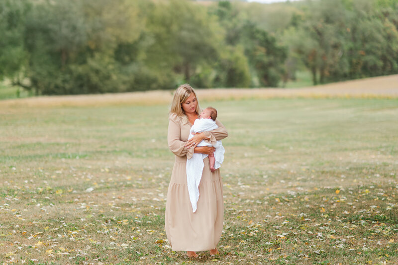 mother holding baby by newborn photographer baltimore