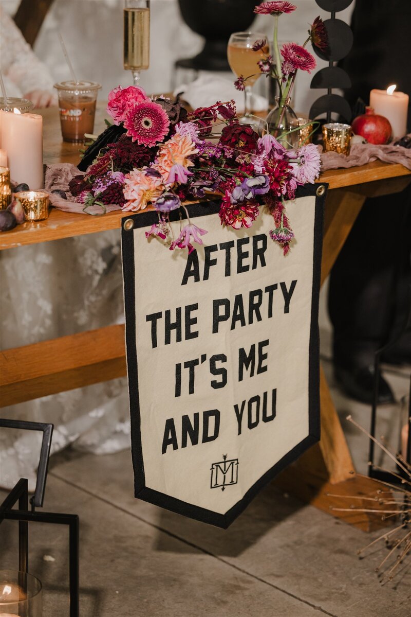 Wedding signage stating after the party it's me and you , hanging from table with bright purple and red florals design by Jessamine floral and events, New Jersey floral designer