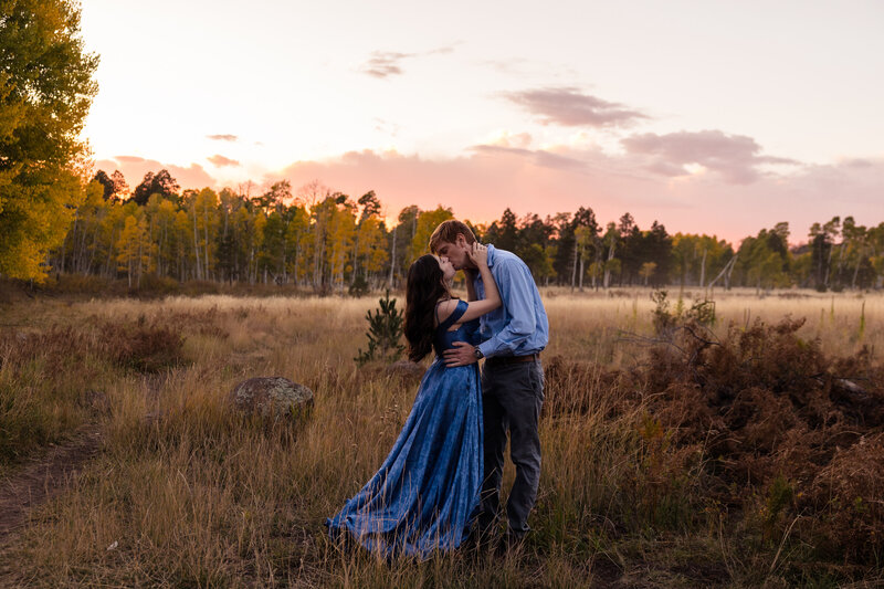 couple kissing in front of the fall leaves