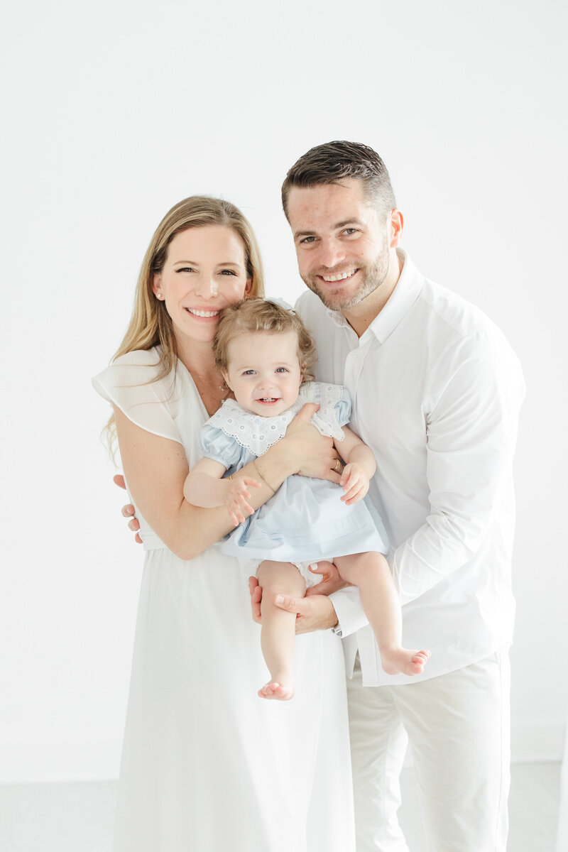 Father and mother hold their baby during first birthday portrait session