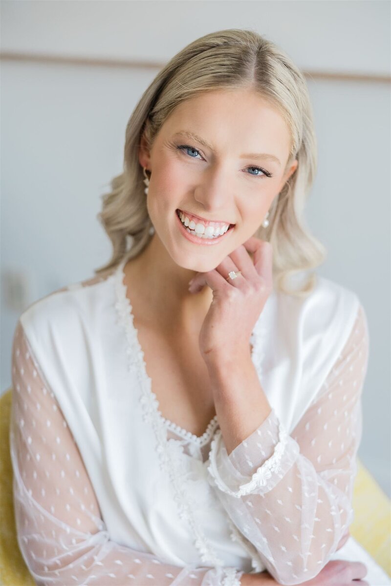 Bride in her wedding robe smiling at the Alfond Inn.