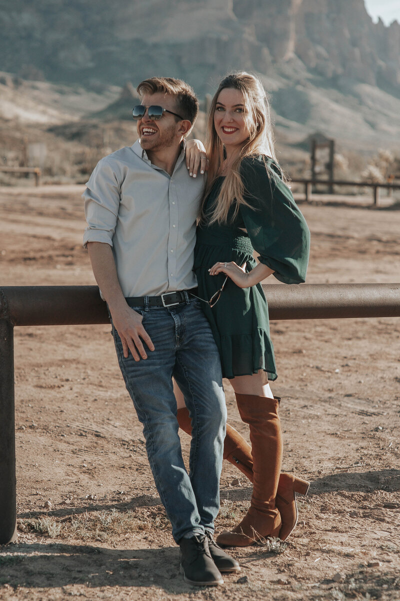 Engaged couple poses for engagement portraits in the desert