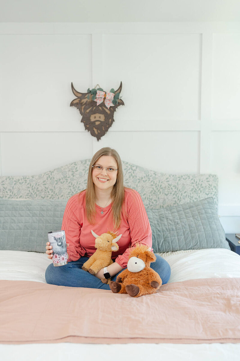 Northern Virginia photographer Melissa Driggers sitting at a desk and smiling at the camera.