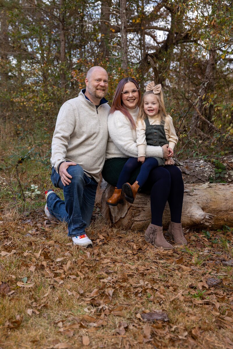 family of three posing on log at Vines Park in Loganville