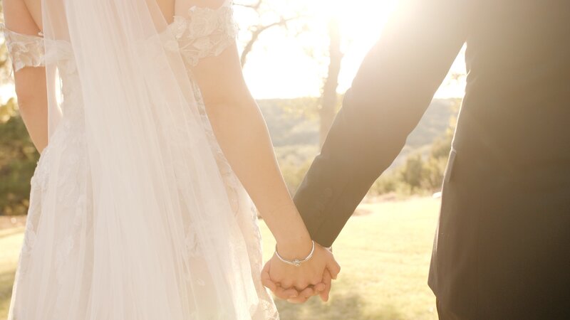 Husband and wife hold hands in bright sunshine in Texas