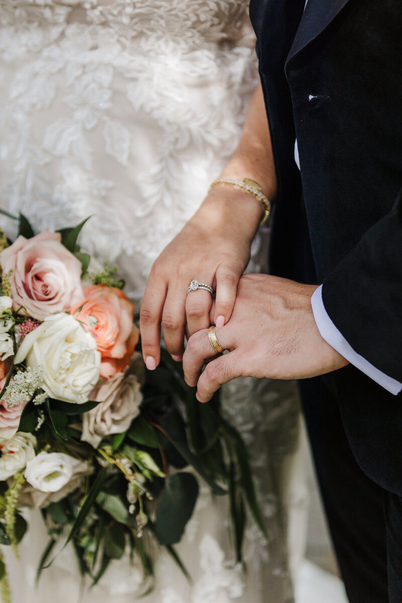 Newly married husband and wife walk along a wooden pier while arm in arm and smiling