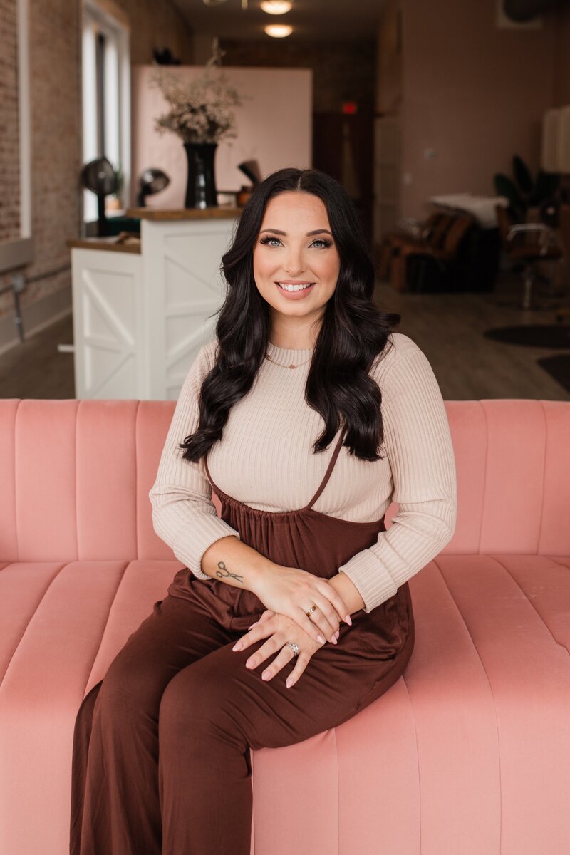 Professional hairstylist with long, dark waves at The Vanity Hair Studio in Griffin, Georgia, known for expert hair coloring and styling services.