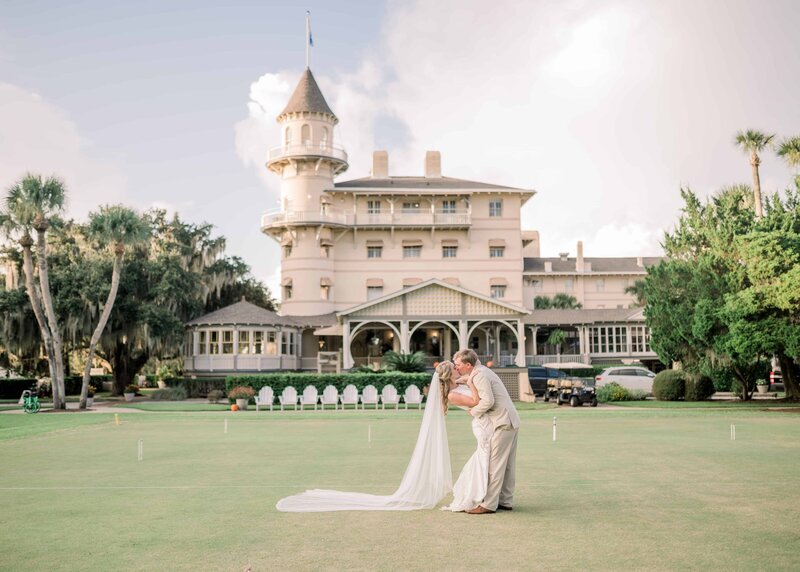 Bride and groom kissing in front of historic mansion in Dallas