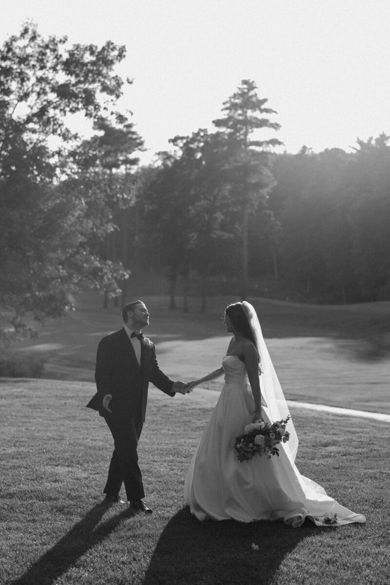 A black and white, candid photo of a bride and groom on their wedding day.