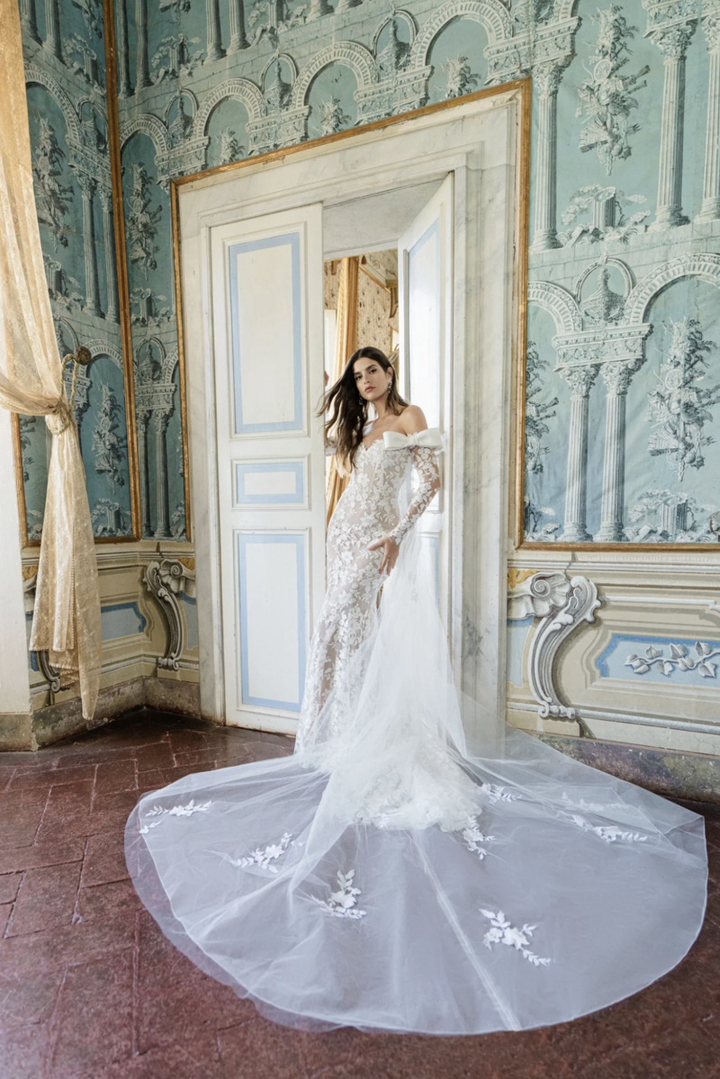 Off-the-shoulder long sleeve trumpet gown with bow details in embroidered sequin lace.