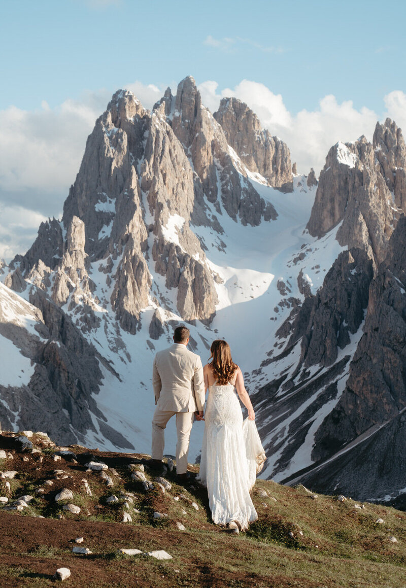 Couple stares at the Cadini mountains during their Dolomites elopement hike