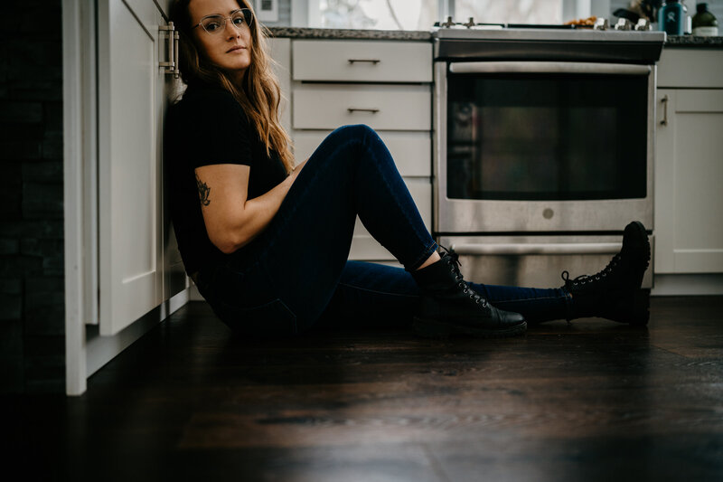 mom sitting on floor in kitchen hiding from kids