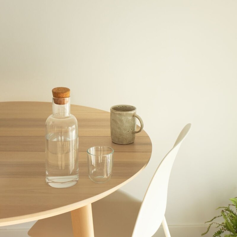 Wooden table with a stone mug and a jug of water with a small glass
