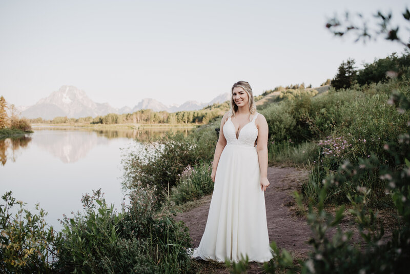 wyoming elopement at oxbow bend with jackson hole wedding  photographers capturing bride standing on a. trail next to a  river
