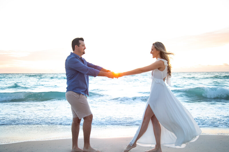 Couple dancing together on the beach at sunrise