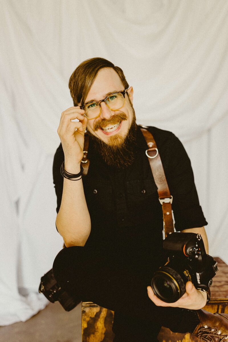 Wedding Photographer Anthony Gauna smiling at camera in studio