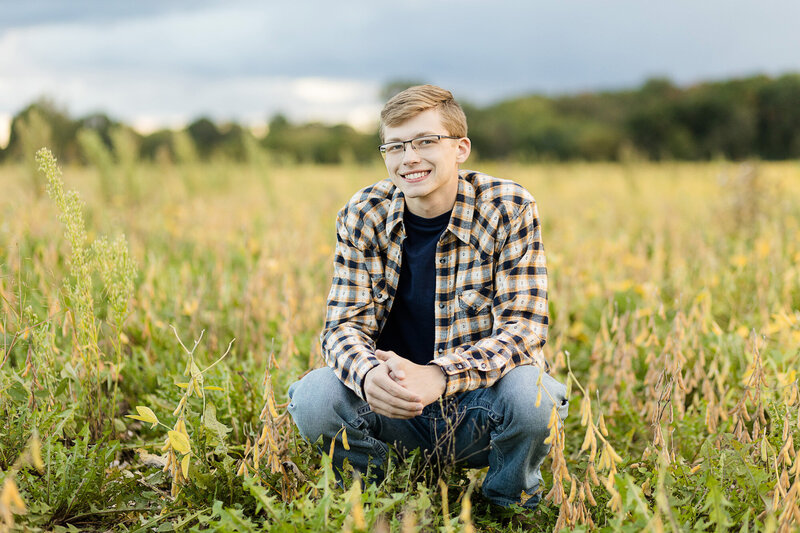 Boy in a field, smiling.