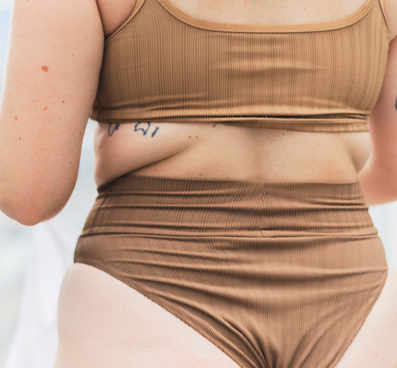 A close up shot of a woman in a brown bikini.