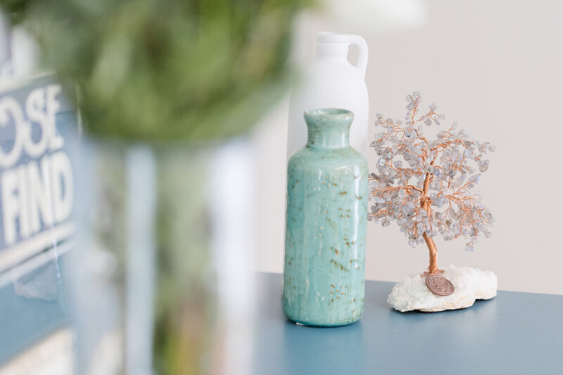 Beautiful jeweled tree sculpture next to teal and white jugs