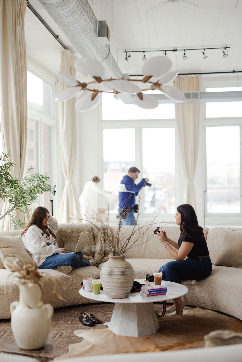 Woman sitting on a furry chair in a studio rental reading the newspaper.