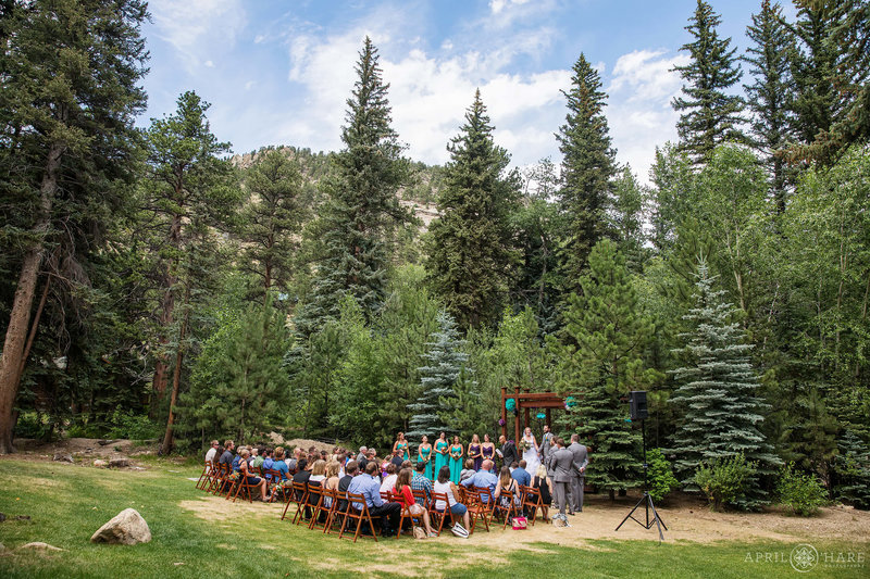 Outdoor wedding ceremony in nature in front of the wood gazebo at Estes Park Condos on Fall River in Colorado