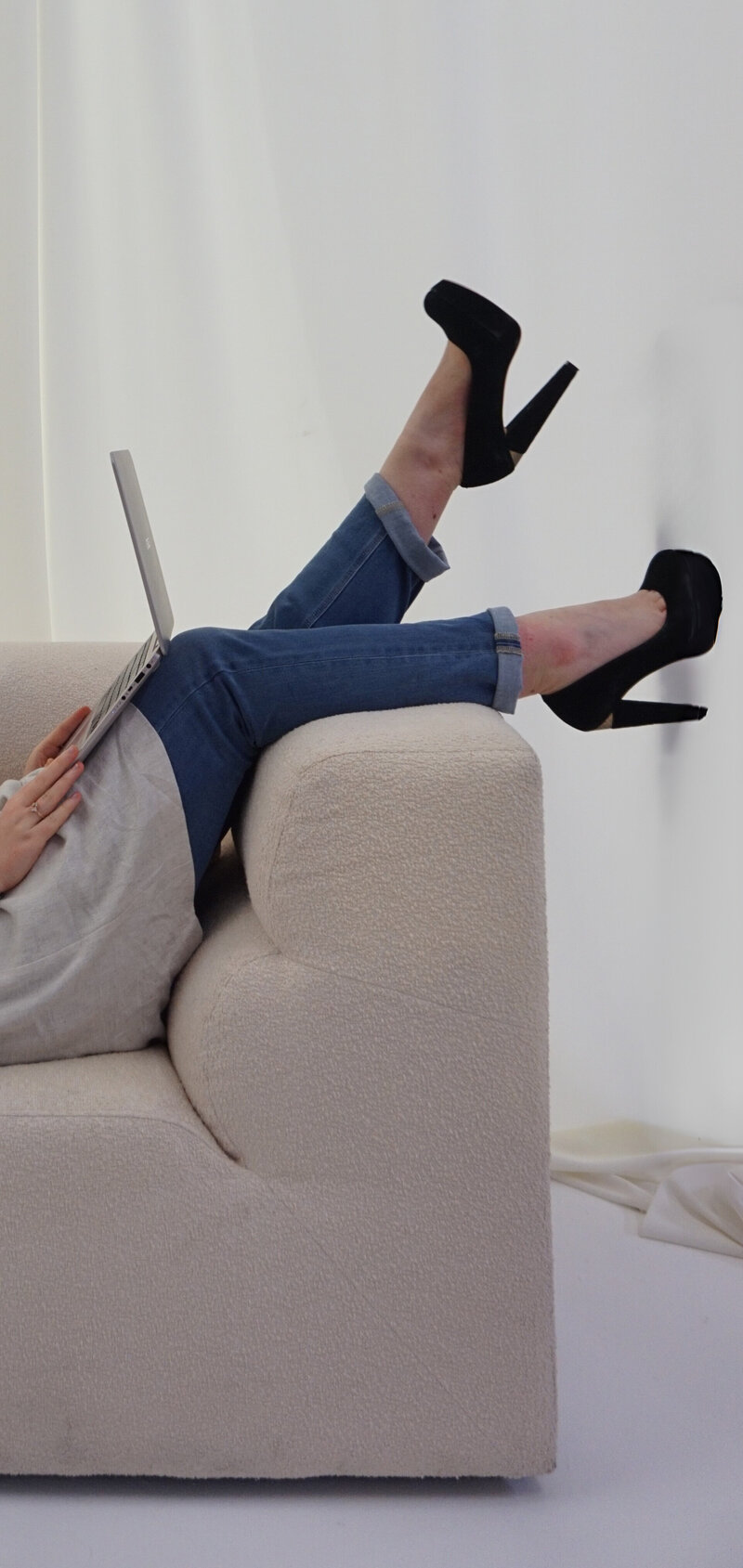 Female operations consultant sitting with her legs in the air whilst on a laptop creating a strategy