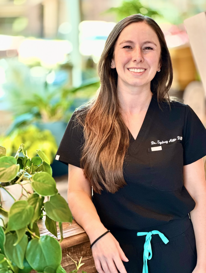 Dr. Allie, a new dentist at 4Scottsdale Smiles, smiling warmly in her professional attire, ready to provide family and cosmetic dental care.